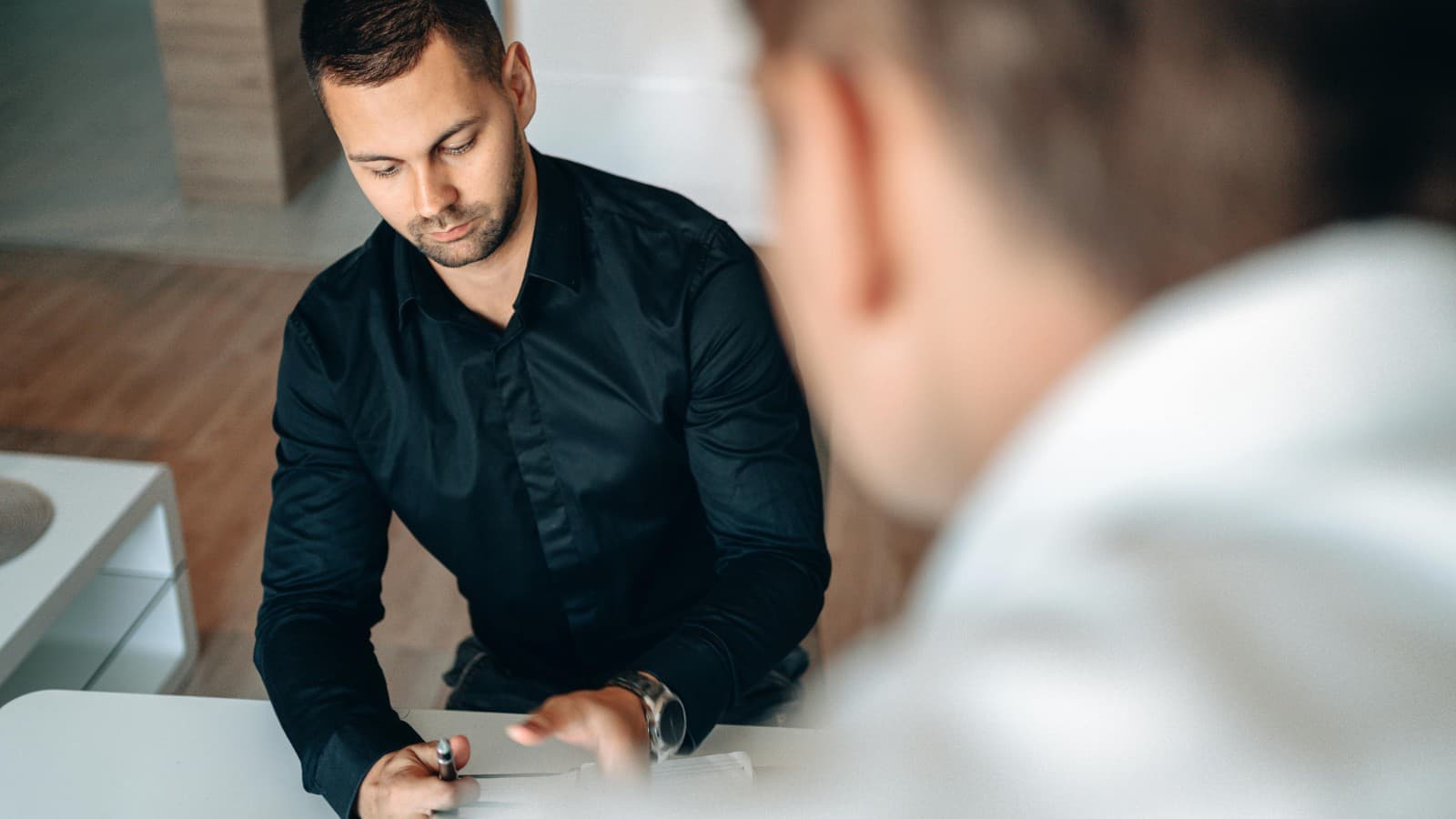 Courtier automobile en consultation avec un client, ambiance bureau professionnel
