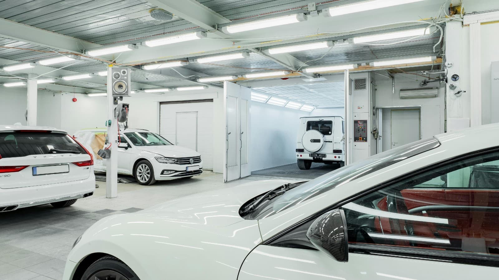 Mécanicien inspectant le moteur d'une voiture allemande premium dans un atelier professionnel