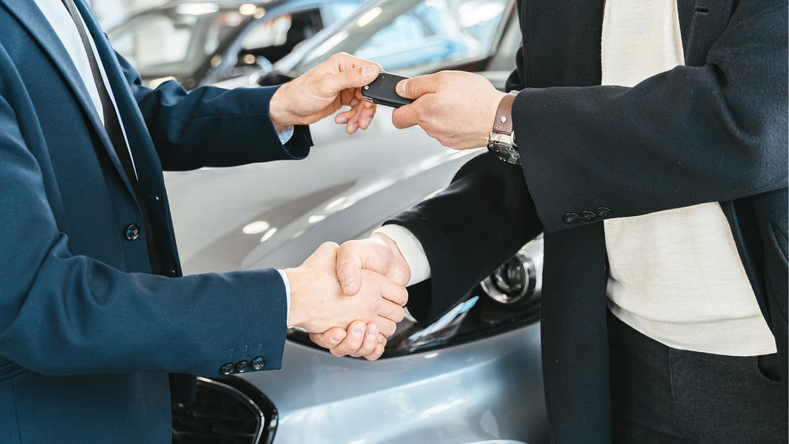Remise de clés à un client dans un showroom premium — moment final d'un import auto réussi