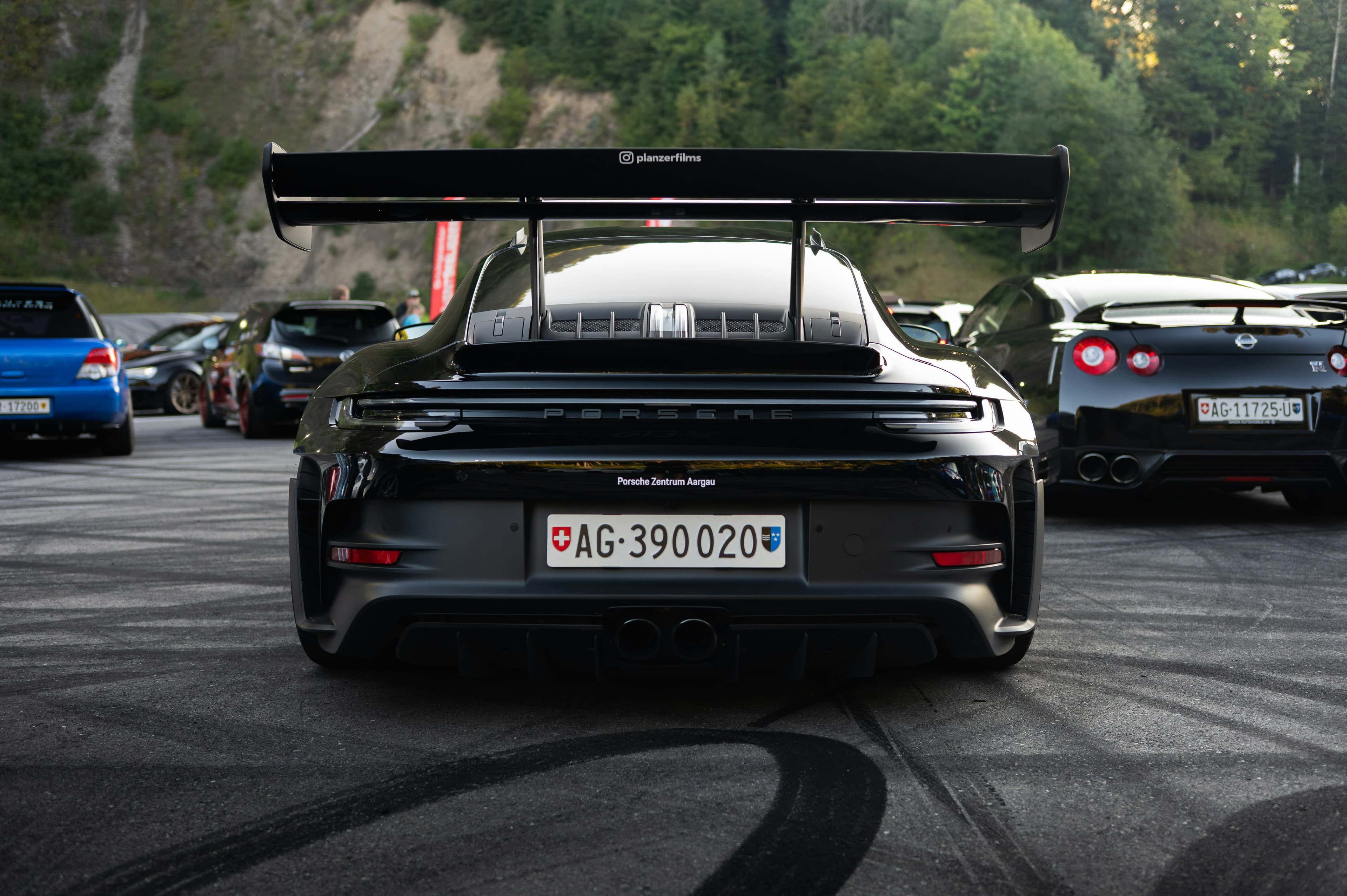 Voiture allemande premium devant un paysage suisse, symbolisant l'importation d'un véhicule d'Allemagne vers la Suisse